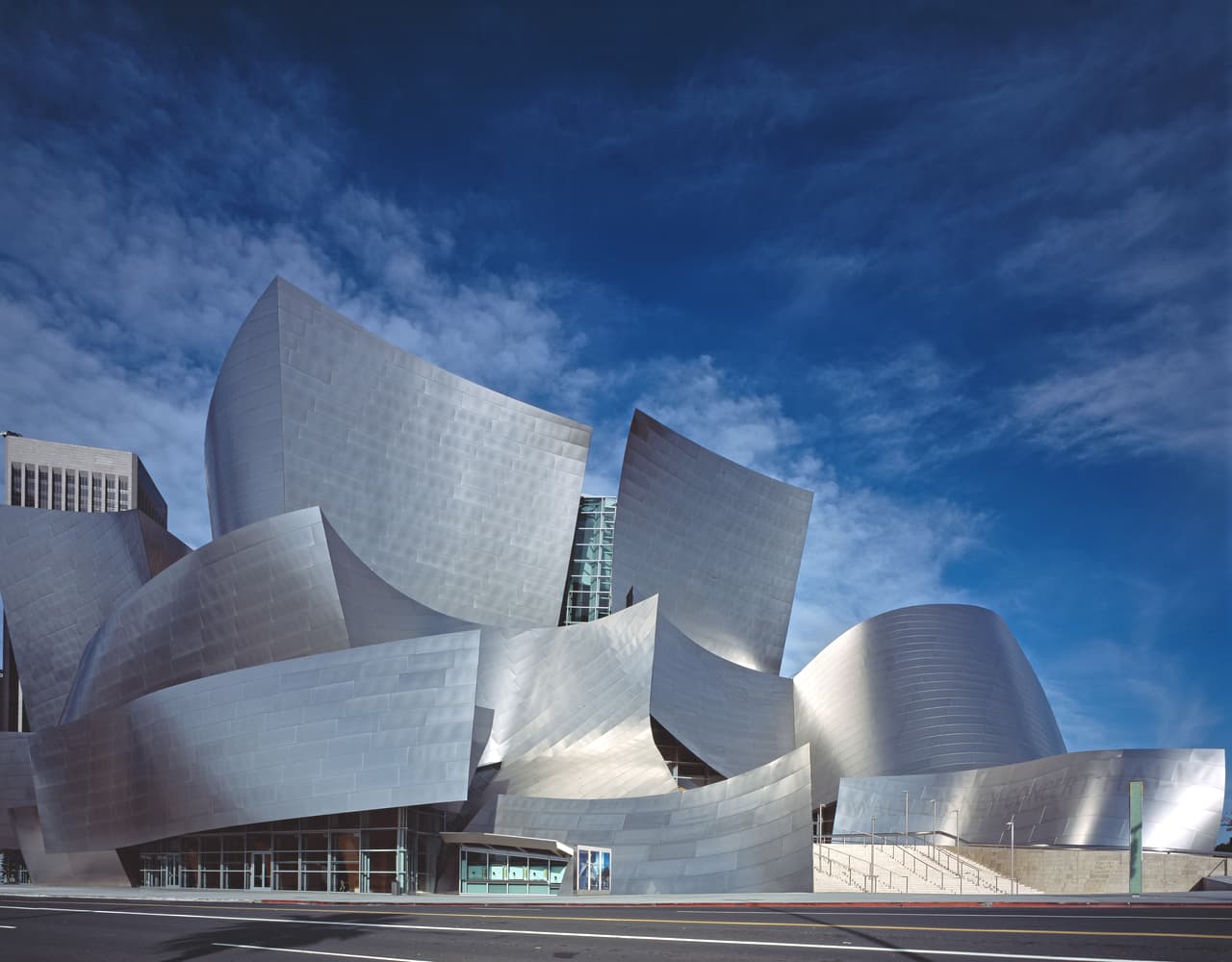 Walt Disney Concert Hall in Los Angeles, designed by Frank Gehry, featuring sweeping stainless-steel curves and layered volumes.