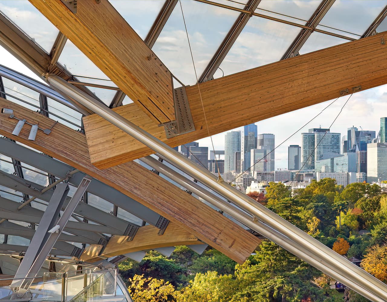 Fondation Louis Vuitton in Paris, designed by Frank Gehry, with glass sail-like forms rising above the surrounding landscape.