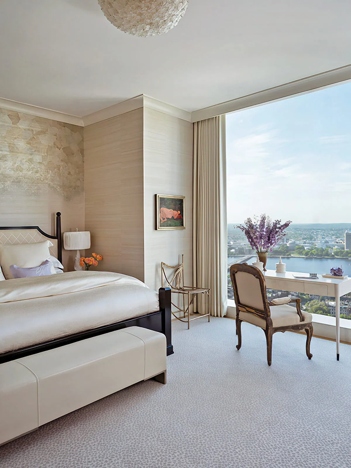 Bedroom with upholstered bed, corner windows, writing desk, and panoramic Boston views at One Dalton Residence.